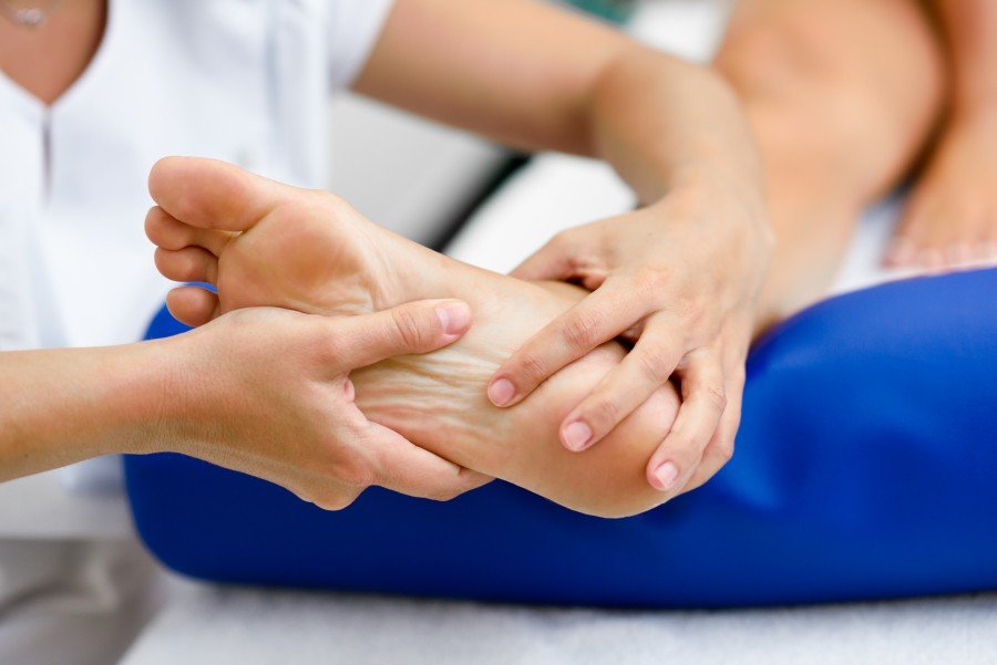 Rheumatologist examining a patient's foot to assess gout symptoms and joint pain during a clinical consultation.